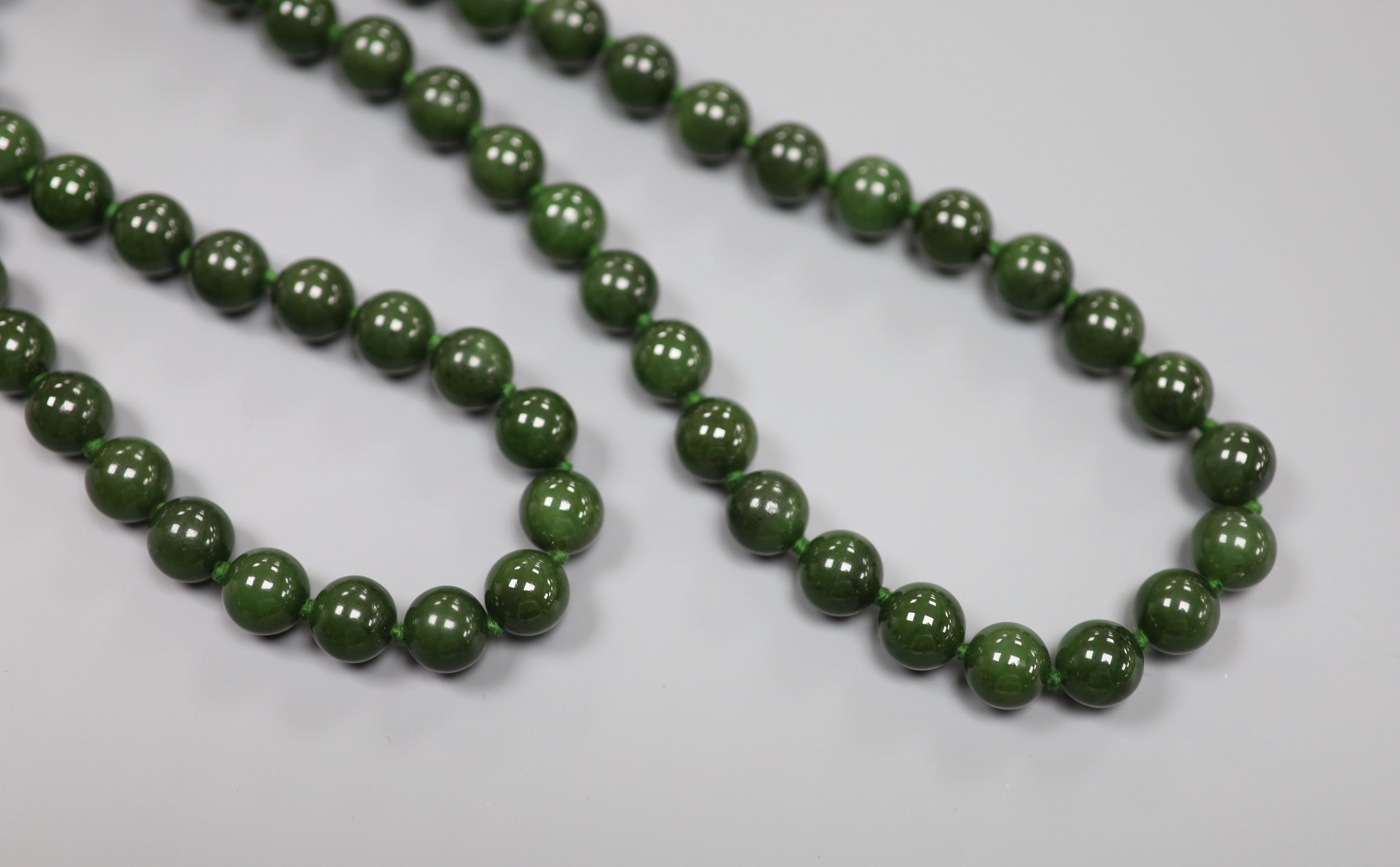 A single strand nephrite circular bead necklace, 82cm, gross weight 171 grams,